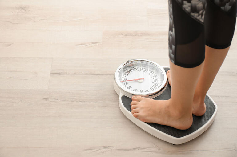 person's feet on scales measuring weight