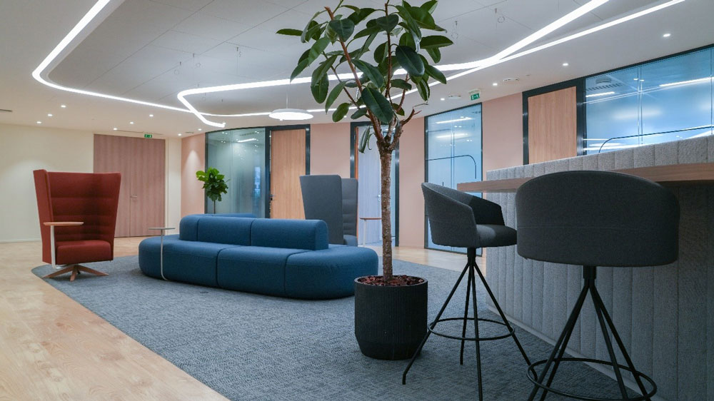 Office coffee station in central space with a couch and high chairs